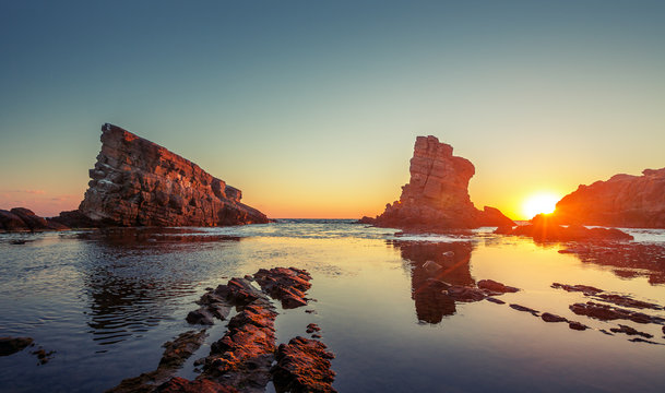 Dramatic Sunrise With Mist On The Beach With Rocks