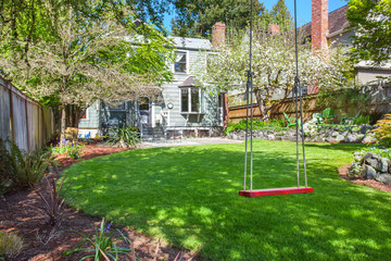 Perfect back yard with tree swing and grass.