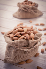 Raw almonds on white wooden board