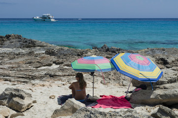 Girl on the beach looking speedboat off