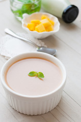 panna cotta, thai tea with mint leaf on white wooden board