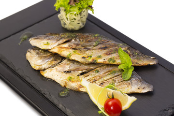 Fried fish dorado with vegetables and lemon