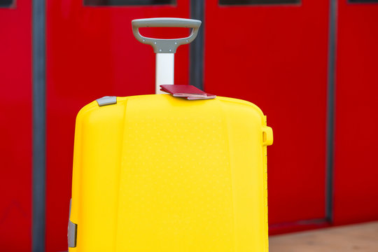 Closeup Red Passports On Yellow Luggage At Train Station