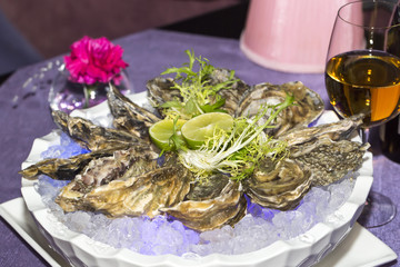oysters on ice in a dish on a table in a restaurant