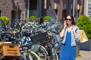 Young caucasian woman talking by cell phone in european city