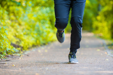 Close-up on shoe of athlete runner man feet running on road 