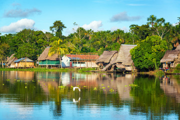 View of a small village in the Amazon rain forest on the shore of the Yanayacu River in Peru - obrazy, fototapety, plakaty