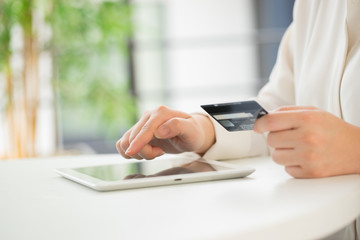 Hands of an office woman typing keyboard with credit card