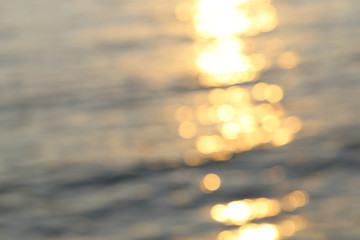 Abstract golden sunlight bokeh on blue sea water background.