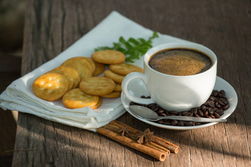 Cup of coffee on a wooden board and biscuits
