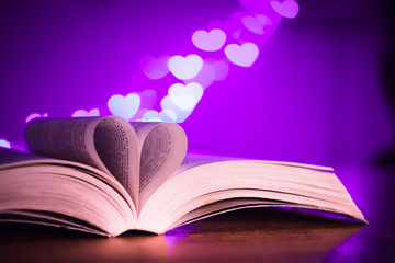 Book with low light and pink bokeh in heart shaped