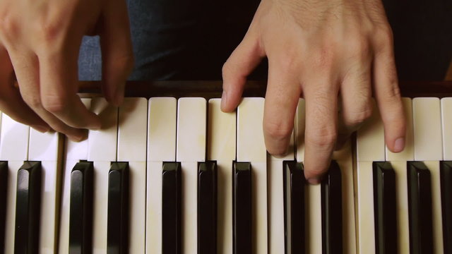 Male piano player hands with dolly slider motion. On a grand piano.
