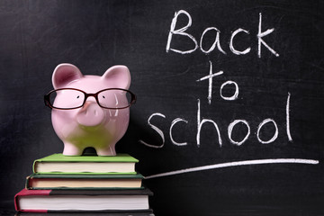 Piggy Bank with back to school message written in chalk on a blackboard school college fund saving money photo