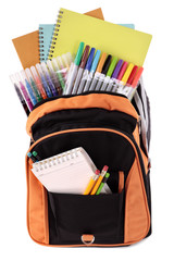 School bag backpack with various books pencils crayons and study equipment isolated on white background photo