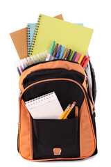 School bag backpack with various books pencils crayons and study equipment isolated on white...
