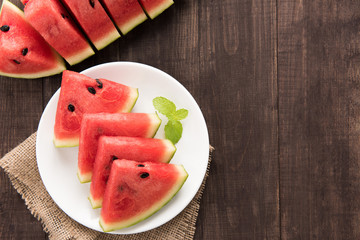 Organic fresh watermelon cut into wedges on wooden background