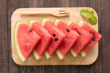 Fresh watermelon pieces placed on wooden background
