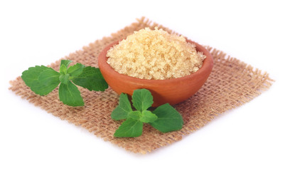 Coarse crystals of brown sugar with stevia leaves