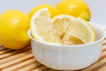 Quartered lemon in white bowl