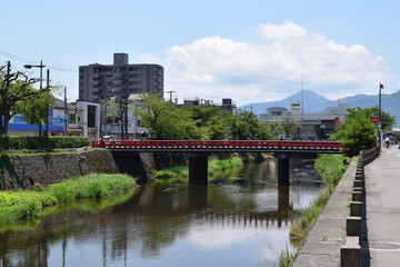 初夏の三雪橋（山形県鶴岡市・内川）／山形県の鶴岡市街地をゆっくりと流れる内川。古くから市民の川として親しまれ、「海坂もの」と呼ばれる藤沢周平の小説に登場する「五間川」のモデルとなった川と言われています。しだれ柳が風にそよぎ、朱ぬりの橋「三雪橋」（みゆきばし）は、小京都の趣を感じさせます。