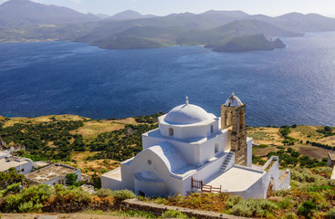 A typical view of the Greek Islands - Greek Orthodox Church white on the mountain against the sea, Plaka village, Milos island, Cyclades, Greece.