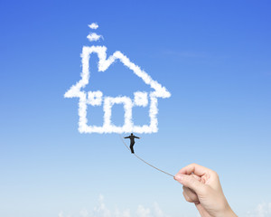 Businessman walking tightrope woman hand pulling toward house cl