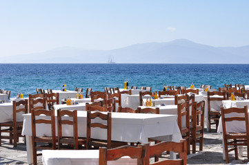 Dining table by the sea are ready for tourist to enjoy their dinner in Mykonos, Greece