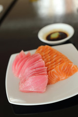 salmon and maguro sashimi on white dish.