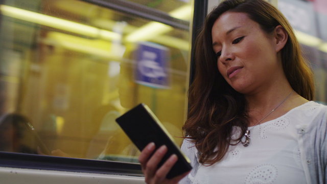 4K Attractive woman on a train reading her phone in slow motion, shot on RED EPIC
