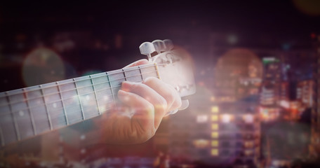 Man playing acoustic guitar with outdoor background