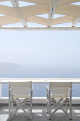 Quiet Terrace for two. Chairs facing out Aegean Sea in a quite and foggy day.