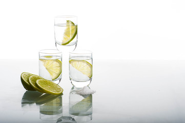 Three shots of vodka with lime