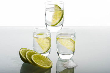 Three shots of vodka with lime