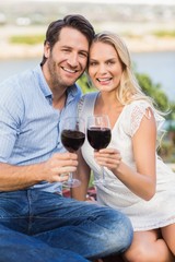 Cute couple on date holding red wine glasses