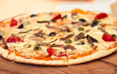 Pizza with meat, tomatoes and olives