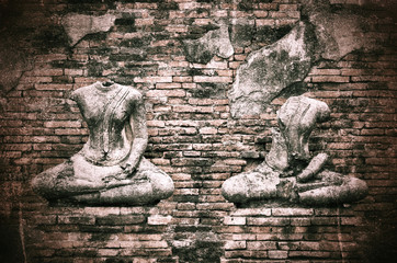 Fototapeta na wymiar Old broken Buddha statue on grunge brick wall background with vi