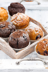 delicious muffins on a wooden tray on white background, vertical