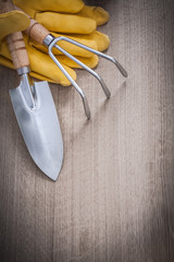 Steel hand shovel rake leather safety gloves on wooden board agr