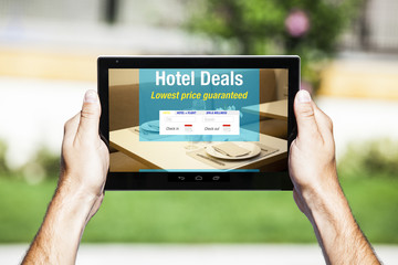 Hotel Deals on tablet. Web template design. Restaurant table setting in the background.