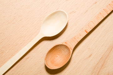 Two wooden spoons of different colors on the surface