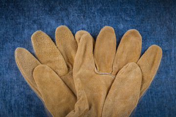 Leather brown construction gloves on scratched metallic surface 