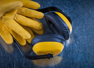 Safety yellow ear muffs and pair of leather construction gloves 