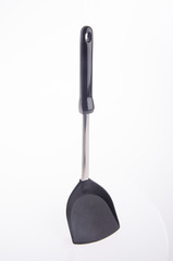 Black plastic kitchen spatula on background.