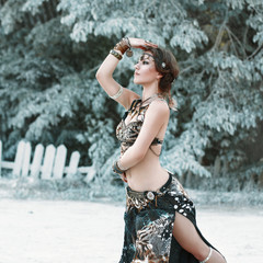 Pretty woman dancing in the tribal style on the background