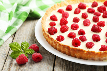 Sweet tart cake with raspberries on grey wooden background