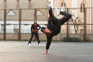 Handsome guy in a stylish black clothes dancing hip-hop. dancer