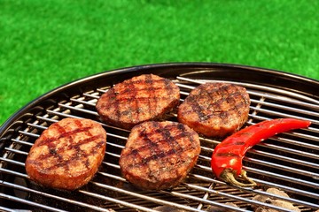 BBQ Hamburger Patties And Chili Pepper On The Hot Grill