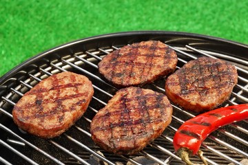 BBQ Hamburger Patties And Chili Pepper On The Hot Grill