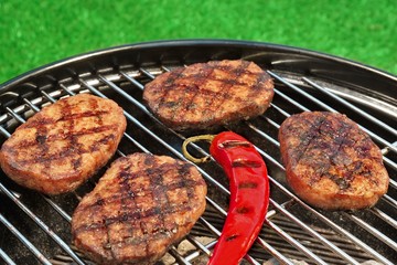 BBQ Hamburger Patties And Chili Pepper On The Hot Grill