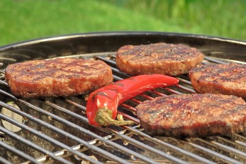 BBQ Hamburger Patties And Chili Pepper On The Hot Grill